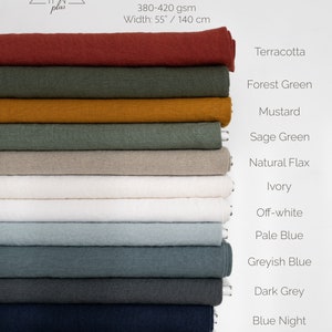 May include: A stack of 11 fabric swatches in various colors, including terracotta, forest green, mustard, sage green, natural flax, ivory, off-white, pale blue, greyish blue, dark grey, and blue night. The fabric is 100% linen and measures 55 inches by 140 centimeters.