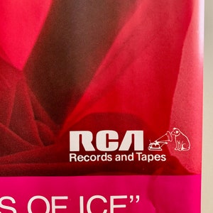 Pu&ograve; includere: Un poster rosa e rosso con il testo "RCA Records and Tapes" e una silhouette bianca di un cane che ascolta un giradischi. Il testo "S OF ICE" &egrave; in fondo al poster.