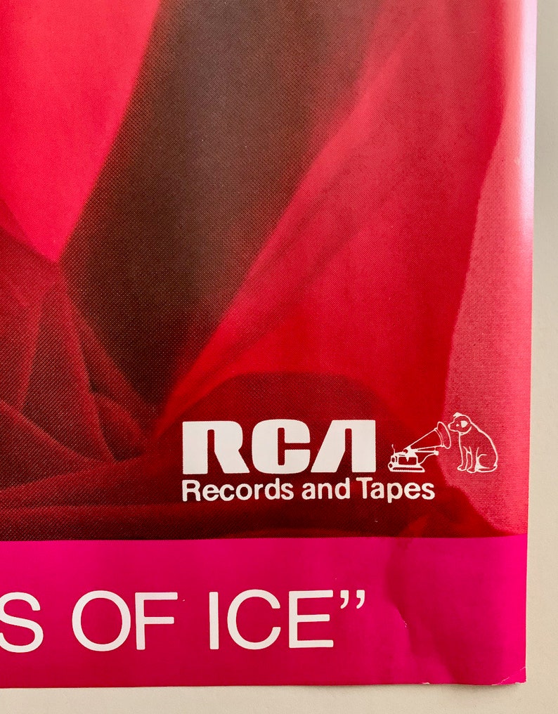 Pu&ograve; includere: Un poster rosa e rosso con il testo "RCA Records and Tapes" e una silhouette bianca di un cane che ascolta un giradischi. Il testo "S OF ICE" &egrave; in fondo al poster.