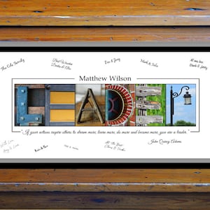 May include: A framed print featuring the word "LEADER" spelled out in colourful letters made from various textures and materials. The quote "If your actions inspire others to dream more, learn more, do more and become more, you are a leader." by John Quincy Adams is printed below the letters. The print is signed by several people.