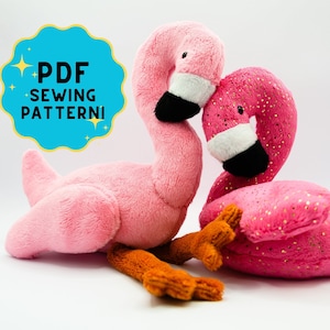 Può includere: Due giocattoli di peluche a forma di fenicottero rosa. Un fenicottero è di colore rosa solido, mentre l'altro ha accenti di glitter dorati. Entrambi hanno occhi e becchi neri.