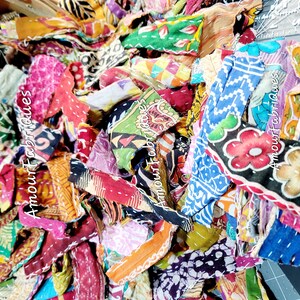 May include: A pile of colorful fabric scraps, some with floral patterns, others with geometric designs. The scraps are arranged in a random order, creating a visually appealing and textured composition.  The text "Amour Fabrics" is visible on some of the scraps.