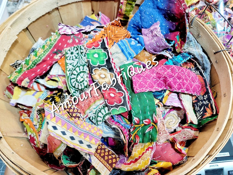 May include: A wooden basket filled with colorful fabric scraps. The scraps are a mix of patterns and textures, including floral prints, paisley designs, and geometric patterns. The fabric scraps are perfect for quilting, patchwork, or other craft projects.