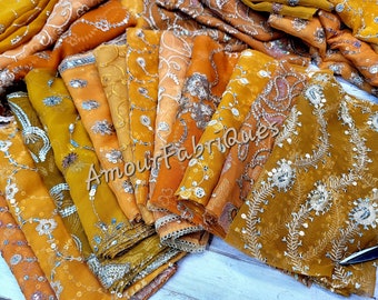 May include: A stack of golden yellow fabric squares with silver embroidery and sequins. The fabric is sheer and delicate, and the embroidery is intricate. The fabric is labeled "Amour Fabriques".