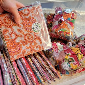 May include: A collection of colorful fabric scraps in plastic bags. The bags are labeled "Thank You".