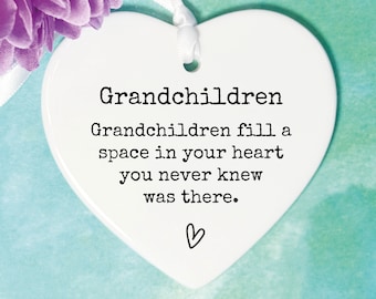 May include: White ceramic heart-shaped ornament with the text "Grandchildren fill a space in your heart you never knew was there." and a small heart symbol.