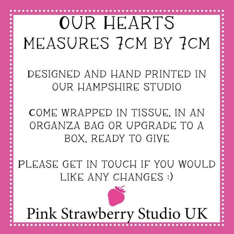 May include: A white square sign with a pink border and white dots, featuring black text: OUR HEARTS MEASURES 7CM BY 7CM, DESIGNED AND HAND PRINTED IN OUR HAMPSHIRE STUDIO, COME WRAPPED IN TISSUE, IN AN ORGANZA BAG OR UPGRADE TO A BOX, READY TO GIVE, PLEASE GET IN TOUCH IF YOU WOULD LIKE ANY CHANGES :), a small pink strawberry icon, and Pink Strawberry Studio UK.