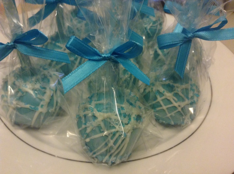 May include: Blue and white cake pops wrapped in clear cellophane bags with blue ribbon bows.