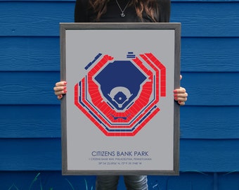May include: A framed print of a baseball stadium seating chart. The chart is in red, blue, and gray. The stadium is called Citizens Bank Park. The text on the print reads "1 Citizens Bank Way, Philadelphia, Pennsylvania 39° 54' 25.0956' N, 75° 59' 59.1948' W."