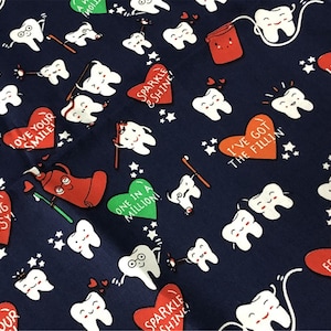 May include: Navy blue fabric featuring a dental-themed pattern. Smiling teeth, red hearts with phrases like "Love Your Smile" and "Feeling Flossy!", and cartoon toothpaste tubes are scattered across the material.