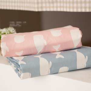 May include: Two fabric swatches with a white whale pattern. The top swatch is pink and the bottom swatch is blue.