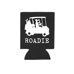 May include: Black and white golf cart design on a black neoprene can cooler with the word "ROADIE" printed below the image.