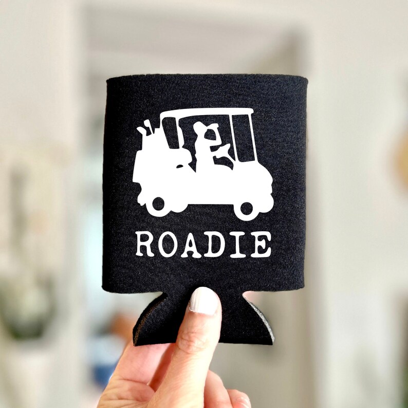 May include: Black neoprene can cooler with a white silhouette of a golf cart and the word "ROADIE" printed on it.