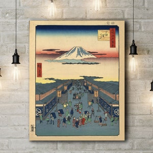 May include: A vintage Japanese woodblock print depicting Mount Fuji in the distance, with a bustling street scene in the foreground. The print is in shades of blue, green, and brown, with a light pink sky.