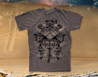 May include: A dark gray t-shirt with a graphic print of a stylized design featuring birds, spirals, and geometric shapes. The design is in black and gold on a gray background. The text "REMARKABLE" and "DESOLATE" is printed at the bottom of the design.