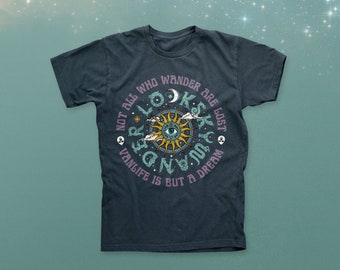 Op de afbeelding: Donkerblauw t-shirt met een cirkelvormig grafisch ontwerp. Het ontwerp toont een zon met een oog in het midden, omringd door de tekst: "Not all who wander are lost. Vanlife is but a dream."
