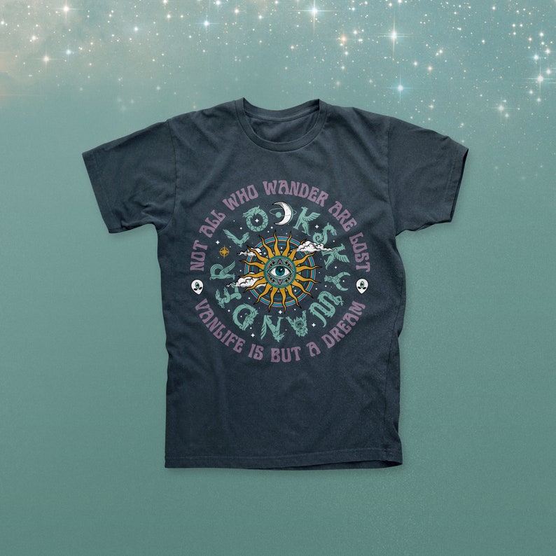 Op de afbeelding: Donkerblauw t-shirt met een cirkelvormig grafisch ontwerp. Het ontwerp toont een zon met een oog in het midden, omringd door de tekst: "Not all who wander are lost. Vanlife is but a dream."