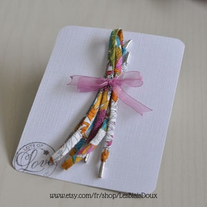 Könnte beinhalten: Ein Set bunter Schnürsenkel mit floralem Muster, gebunden mit einem rosa Band und einem silbernen Anhänger mit der Aufschrift "Lots of Love". Die Schnürsenkel werden auf einer weißen Karte mit der Website-Adresse "www.etsy.com/fr/shop/LesBiaisDoux" präsentiert.