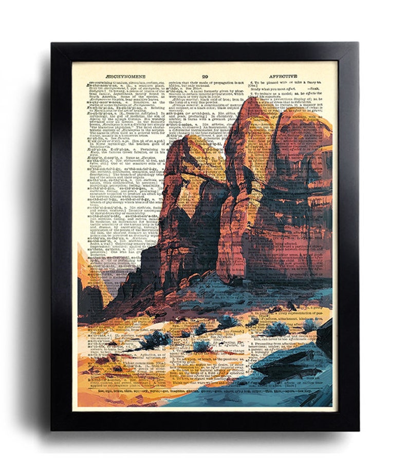 Puede incluir: Una p&aacute;gina de diccionario vintage con una imagen pintada de un paisaje des&eacute;rtico. La imagen presenta grandes formaciones rocosas rojas, un primer plano arenoso y peque&ntilde;os arbustos verdes. El texto de la p&aacute;gina est&aacute; en blanco y negro.