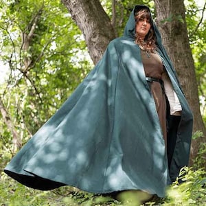 May include: A dark green hooded cloak with a long flowing design. The cloak is made of a soft, comfortable fabric and has a simple, elegant style.