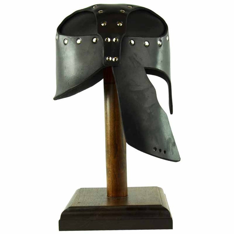 May include: Black leather helmet with a decorative design of metal studs. The helmet is on a wooden display stand.