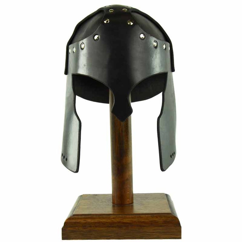 May include: A black leather helmet with a studded design, displayed on a wooden stand. The helmet has a rounded top and a pointed chin guard.