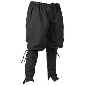 K&ouml;nnte beinhalten: Schwarze Hose im mittelalterlichen Stil mit Kordelzugbund und eng anliegenden Unterschenkeln. Die Hose hat eine lockere, weite Passform an den Oberschenkeln und ist aus einem einfarbigen, dunklen Stoff gefertigt. Die Unterschenkel sind mit B&auml;ndern an den Kn&ouml;cheln versehen.