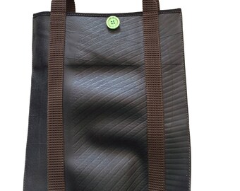 May include: A brown recycled tire tote bag with brown straps and a green button.