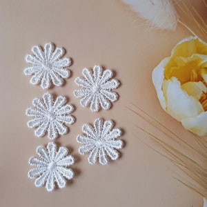 May include: Six white lace flower appliques with a delicate design. The appliques are perfect for adding a touch of elegance to any craft project.