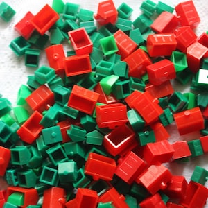 Może przedstawiać: Duża sterta czerwonych i zielonych plastikowych domków. Domki są małe i mają prosty design.