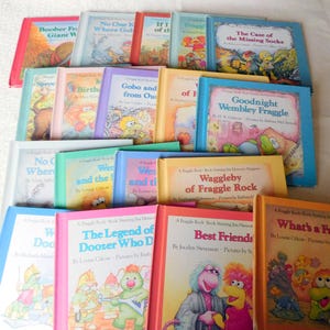 Op de afbeelding: Een verzameling kleurrijke kinderboeken met verschillende titels en illustraties. De boeken hebben verschillend gekleurde covers, waaronder rood, blauw, roze en geel, met titels als "Goodnight Wembley Fraggle" en "Best Friends". De boeken zijn in centimeters.