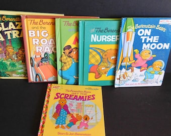 May include: A collection of ten children's books featuring the Berenstain Bears. The books have colourful covers with illustrations of the bears in various settings, including a rocket ship, a car, and a nursery. The titles of the books include "The Berenstain Bears and the Big Road Race", "The Berenstain Bears Go to the  Nursery", "The Berenstain Bears On the Moon", and "Help! The Berenstain Bears Get the Screamies".