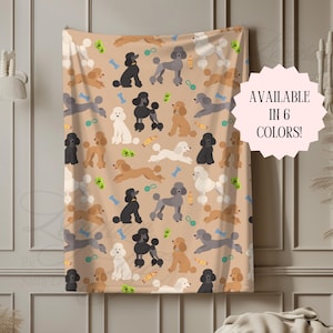 Peut inclure: Une couverture jeté de couleur beige avec un motif répétitif de caniches de différentes couleurs, notamment noir, blanc, gris et marron, parsemé de petits jouets pour chiens et d'os. Un badge circulaire rose indique AVAILABLE IN 6 COLORS!