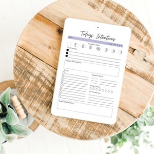 May include: A white digital planner with the text "Today's Intentions" and a section for daily affirmations, to-do list, appointments, water intake, and reflections. The planner also includes a moon phase tracker.