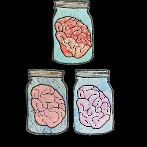 May include: Three glass jars with lids, each containing a pink, red, or blue brain. The jars have a blue and white tie-dye pattern.