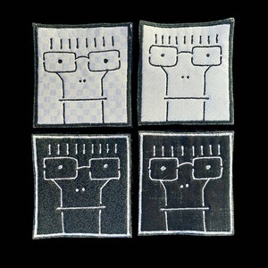 Könnte beinhalten: Vier gestickte Aufnäher mit einer Comicfigur mit Brille. Zwei Aufnäher haben ein weißes Design auf schwarzem Hintergrund, und zwei Aufnäher haben ein schwarzes Design auf weißem Hintergrund.