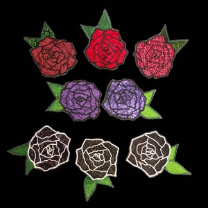 May include: Seven embroidered fabric rose patches in various colors, including red, pink, purple, and black. Each rose has a green stem and leaves.