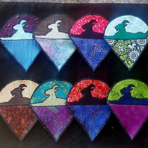 May include: Set of ten fabric appliques featuring a silhouette of a goat in various colors and patterns. The appliques are shaped like a triangle and have a black outline.