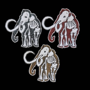 Puede incluir: Tres parches bordados que representan a un par de mamuts lanudos abrazándose. Los mamuts son blancos con contornos negros y se muestran como esqueletos. Los parches están en tres esquemas de color diferentes: gris y negro, rojo y negro, y marrón y dorado.