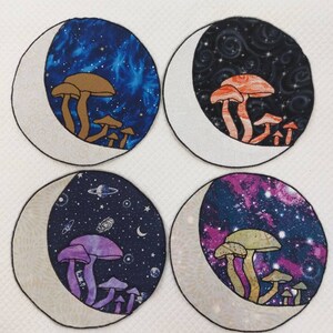 May include: Four round fabric patches with a crescent moon design. Each patch features a different galaxy-themed background with a cluster of mushrooms in the center. The mushrooms are different colors, including brown, orange, purple, and green.