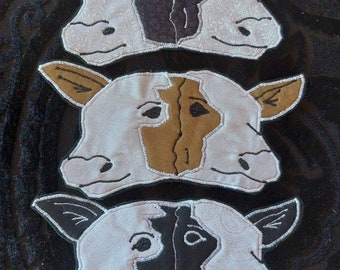 May include: Three felt cow masks, each with a different colored patch on the face. The top mask has a black patch, the middle mask has a brown patch, and the bottom mask has a black patch.
