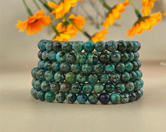 May include: A stack of eight turquoise and green gemstone bracelets. Each bracelet is made of small, round beads.