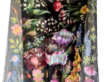 May include: A black silk scarf with a floral print featuring various flowers in shades of pink, purple, blue, and yellow. The flowers are arranged in a random pattern on a black background.