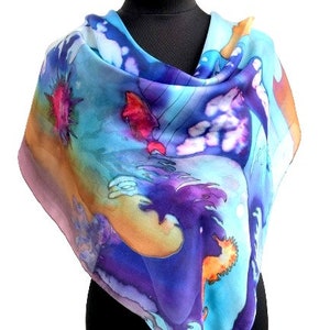 May include: A silk scarf with a colorful abstract design featuring shades of blue, purple, orange, and pink. The design resembles waves and clouds.