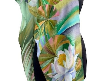 May include: A green and blue silk scarf with a hand-painted design of water lilies and leaves. The scarf is on a black mannequin.