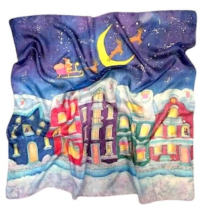 May include: A silk scarf with a winter scene. The top portion depicts a starry night sky with a crescent moon and reindeer. The bottom half shows a snow-covered town with colorful buildings. The scarf is a square shape.