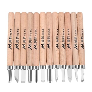 May include: A set of twelve wood carving tools with light-colored wooden handles and metal blades. Each handle features the black printed text "MYTEC" and Chinese characters. The tools include various blade shapes such as gouges and chisels.