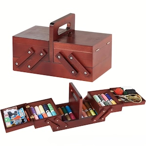 May include: A dark brown wooden sewing box with a cantilevered design. The box features a central handle and multiple tiered compartments that fold out to reveal various sewing supplies, including colorful thread spools, buttons, and scissors.
