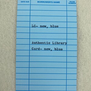 May include: A blue library card with the text "LC-new, blue" and "Authentic Library Card-new, blue". The card has fields for "Date Due", "Borrower's Name", and "Room Number".