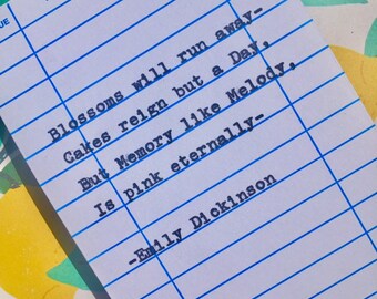 Puede incluir: Una tarjeta de biblioteca azul y blanca con una cita de Emily Dickinson: "Las flores se irán - Los pasteles reinarán pero un día, Pero la memoria como la melodía, Es rosa eternamente - Emily Dickinson"